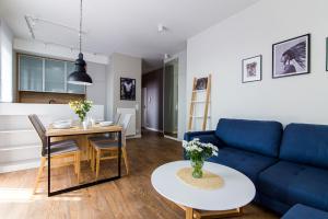 a living room with a blue couch and a table at Apartamenty City Tower od WroclawApartament-pl in Wrocław