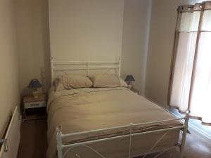 a white bed in a room with a window at Castle Gate House Derry City Centre Townhouse STILL OPEN in Derry Londonderry
