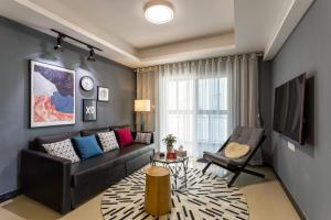 uma sala de estar com um sofá e uma cadeira em Wuhan Jianghan·Hankou Railway Station· Locals Apartment 00120600 em Wuhan