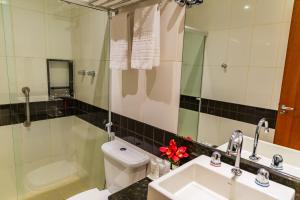 a bathroom with a sink and a toilet and a mirror at Hotel Vermont Ipanema in Rio de Janeiro