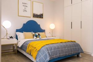 ein Schlafzimmer mit einem blauen Bett und einer gelben Decke in der Unterkunft Wuhan Wuchang·Qunxingcheng Square · Locals Apartment 00121920 in Wuhan