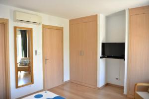 Habitación con armario, TV y espejo. en Guesthouse Le Châtelain, en Santa Maria