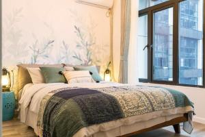 a bedroom with a large bed with a window at Wuhan Wuchang·Happy Valley· Locals Apartment 00121930 in Wuhan