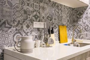 a kitchen counter with cups and a sink at Wuhan Wuchang·Happy Valley· Locals Apartment 00121930 in Wuhan