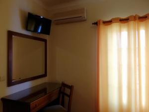 オデミラにあるResidencial Idalioのベッドルーム1室(鏡、ドレッサー、窓付)