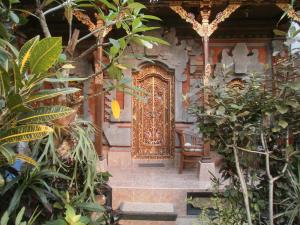 una entrada a una casa con una puerta de oro en Alamanda Accomodation, en Ubud