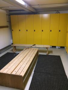 a locker room with yellow lockers and a wooden bench at Dachstein Mountainview Gosau in Gosau