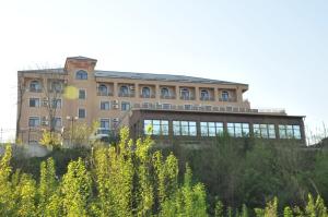 un grande edificio di fronte a un campo di piante di Grand Hotel Orient Braila a Brăila