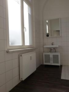 クヴェードリンブルクにあるEddy's Dinerの白いタイル張りのバスルーム(シンク、窓付)