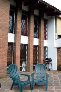 2 chaises bleues et une table en face d'un bâtiment dans l'établissement OH ESPAÑA!, à Guatemala