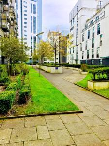 a park with grass and buildings in a city at River Clyde West End Apartment - 2 Bedrooms in Glasgow