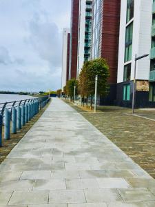 a sidewalk in front of some tall buildings at River Clyde West End Apartment - 2 Bedrooms in Glasgow