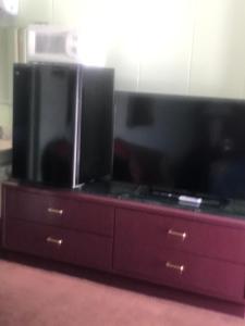 a entertainment center with two large flat screens on it at Itascan Motel in Grand Rapids