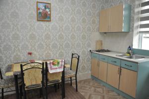 a kitchen with a table and a sink and a table and chairs at Apartments Firuze in Gabala