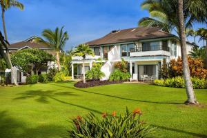 a house with a green yard with palm trees at Aston At Poipu Kai in Koloa