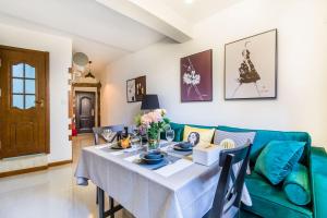 a living room with a table and a green couch at Qingdao Shinan·Qingdao Landing Stage· Locals Apartment 00133930 in Qingdao