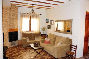 een woonkamer met een bank en een open haard bij Casa Rural Los Montones in Carcelén