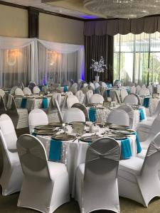 a banquet hall with white tables and chairs at Days Inn & Suites by Wyndham Rochester Hills MI in Rochester Hills