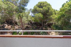 a white railing on a bridge with trees in the background at Hotel Simius Playa in Villasimius