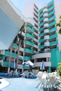 馬薩特蘭的住宿－Hotel Playa Marina，大楼前的带椅子和遮阳伞的酒店