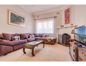 a living room with a couch and a tv at Comfy family home in chill beachside neighbourhood in Sydney