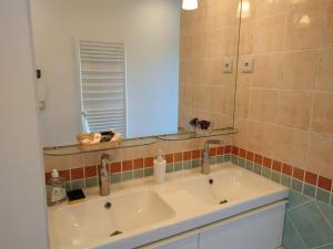 een badkamer met een wastafel en een spiegel bij L'Orée de Versailles in Versailles +5 foto's