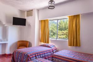 a hotel room with two beds and a window at Hotel Encino Malecón Centro Puerto Vallarta in Puerto Vallarta