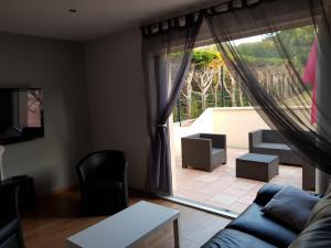 a living room with a couch and a large window at Maison, 5km de la mer in Fontaine-Henry