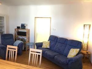 salon z niebieską kanapą i dwoma krzesłami w obiekcie Ferienhaus Karoline w mieście Pulkau