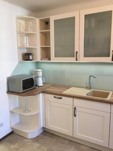 kuchnia z białymi szafkami i mikrofalówką w obiekcie Ferienhaus Karoline w mieście Pulkau