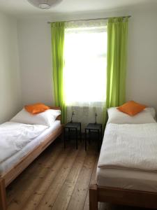 2 łóżka w pokoju z oknem z zielonymi zasłonami w obiekcie Ferienhaus Karoline w mieście Pulkau
