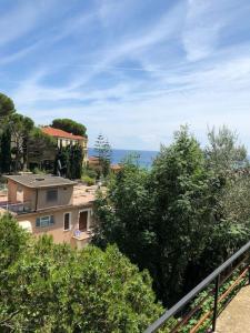 een uitzicht op een huis met bomen en de oceaan bij casa Fantulìn Mare in Laigueglia