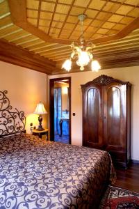 Boutique Hotel Kokkino Spiti في فيريا: غرفة نوم بسرير كبير وسقف خشبي