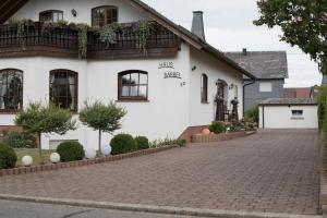 a white house with a brick driveway at Haus Bärbel in Geisfeld