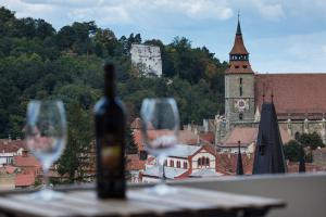 a bottle of wine and two wine glasses on a table at UpperHouse Suites & More in Braşov