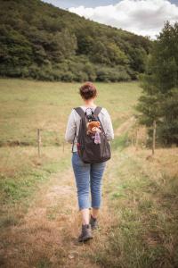 a woman walking down a dirt road with a backpack at Haus Bärbel in Geisfeld