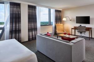 亞特蘭大的住宿－Kimpton Overland Hotel - Atlanta Airport, an IHG Hotel，酒店客房配有床、沙发和电视。