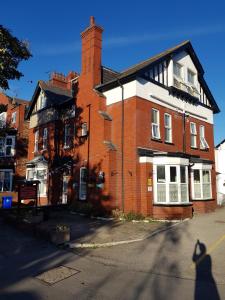 un edificio de ladrillo rojo con una ventana blanca en Ivanhoe Guest House, en Bridlington