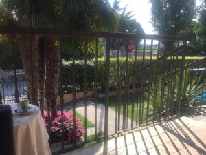 a wrought iron fence with pink flowers on a patio at Franciacorta Suite in Corte Franca