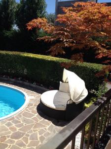 a bed sitting next to a pool next to a fence at Franciacorta Suite in Corte Franca