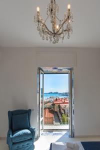 a living room with a blue chair and a mirror at Relais Mareluna - Luxury Apartments in Salerno