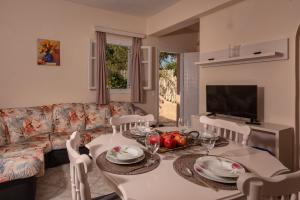 a living room with a table and a couch at Vasiliki Apartments in Tragaki
