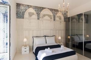 a bedroom with two beds and a chandelier at Relais Mareluna - Luxury Apartments in Salerno