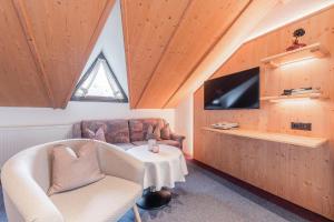 a living room with a couch and a table and a tv at Alpin Apart Maurer in Längenfeld
