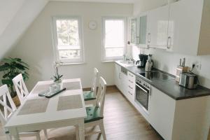 a white kitchen with a table and a table and chairs at Ferienwohnung Worpsweder Schlösschen in Worpswede