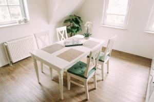 Biały stół jadalny i krzesła w pokoju w obiekcie Ferienwohnung Worpsweder Schlösschen w mieście Worpswede