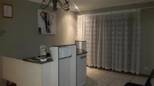 a kitchen with a counter and a window with curtains at TINTECH BED & BREAKFAST in Francistown