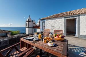 un tavolo in legno con un cesto di frutta sul balcone di T1 Casa das Pereiras a Calheta de Nesquim