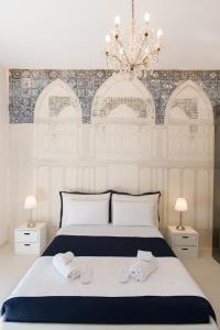 a bedroom with a white bed with two towels on it at Relais Mareluna - Luxury Apartments in Salerno