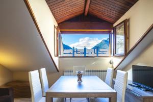 a dining room with a table and chairs and a window at Apartamentos Casa Ríos in Biescas